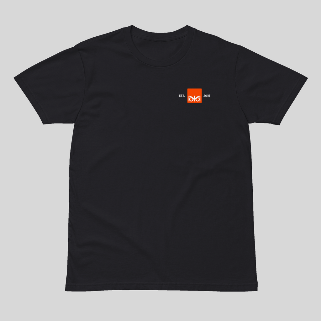 Black t-shirt with a small orange logo on a light gray background